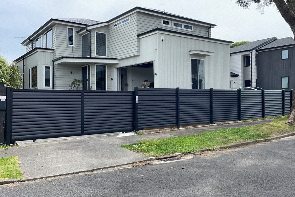 Modern houses with a black metal fence on a residential street